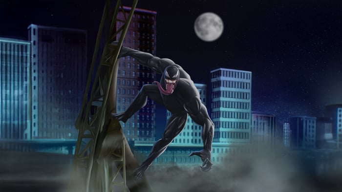 Venom climbs a structure in a city at night