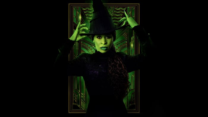 Elphaba from Wicked adjusting her hat