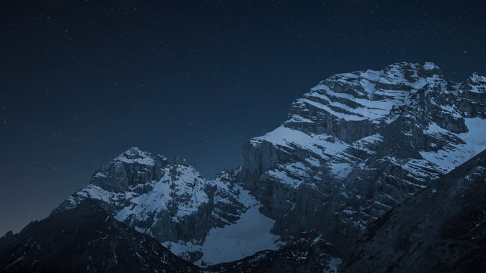 Snowy mountains under a starry night sky