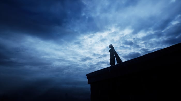 Batgirl on a rooftop overlooking the city at night