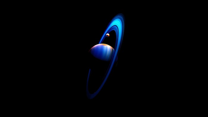 Planet with blue rings and a moon in space