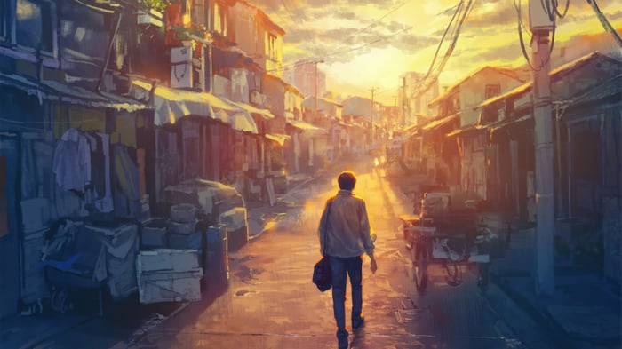 Man walking down a street at sunset
