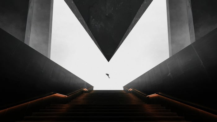 Man dives between dark architectural structures