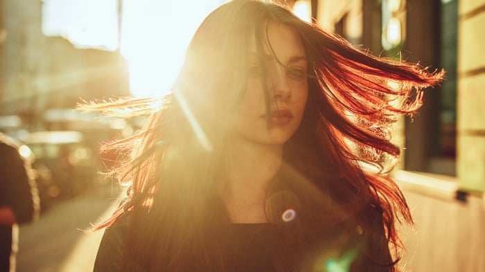 Girl with windblown hair in sunbeams