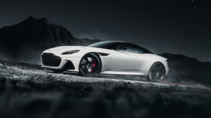 White Aston Martin DBS Superleggera on rocky terrain at night