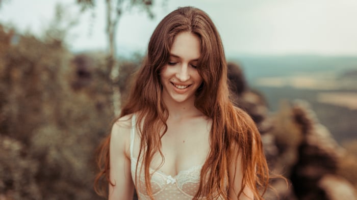 Woman in white lingerie smiling outdoors