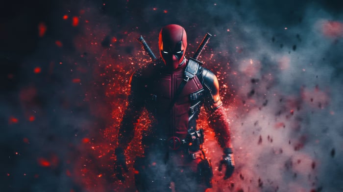 Deadpool standing amidst red embers and smoke