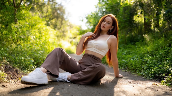 Maia sitting on a path in a forest