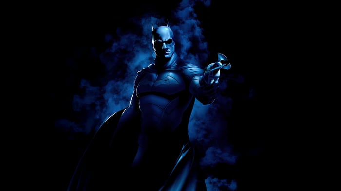 The Batman holding a Batarang in smoke