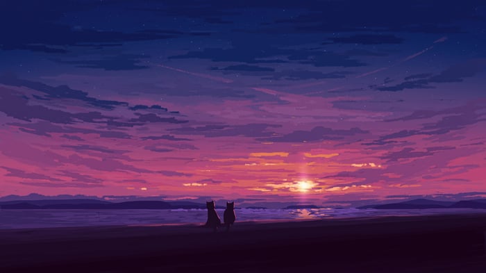 Two cats sit on a beach watching the sunset
