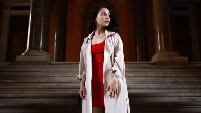 Woman in red dress and long coat on stairs