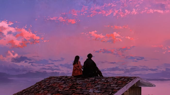 Couple sitting on a rooftop at sunset