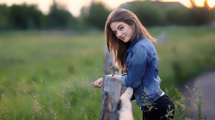 Girl in denim jacket at sunset in fields
