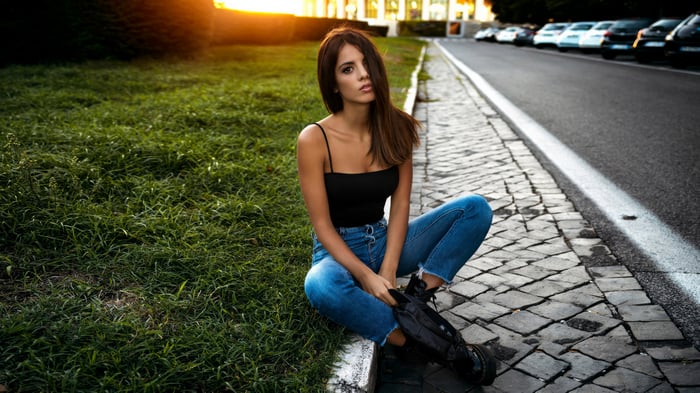 Girl sitting on the side of the road