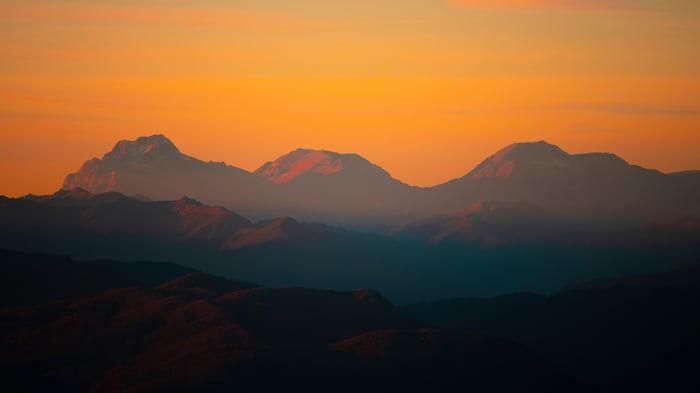 Mountain peaks at sunrise with orange sky