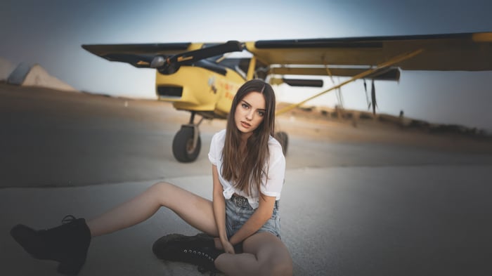 Girl Posing Beside a Yellow Airplane
