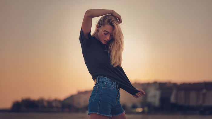 Girl with glasses in black shirt and denim shorts
