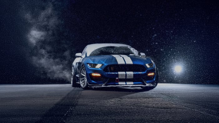 Blue Ford Mustang with white stripes in snow