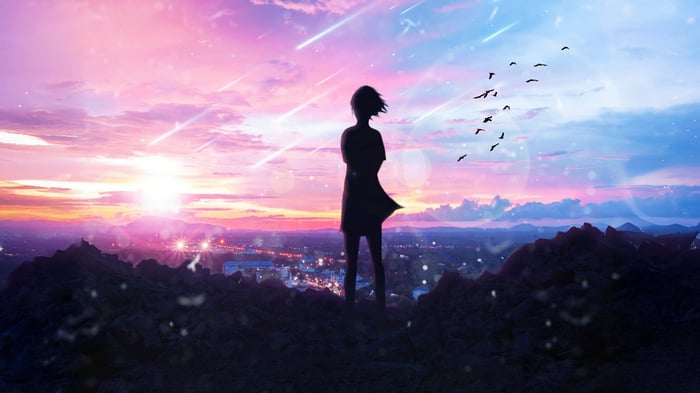Girl Standing on Mountain Overlooking City at Sunset