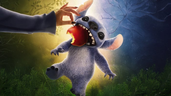 Stitch eating an apple with a hand feeding him