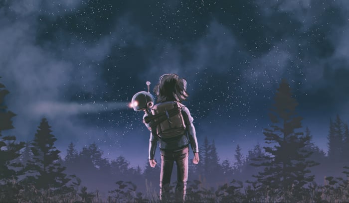 Person with a robot in a forest at night