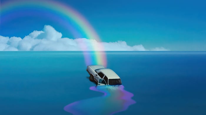 Car submerged in water under a rainbow