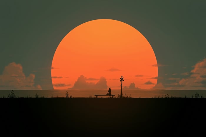 Girl on a bench waiting for a train at sunset