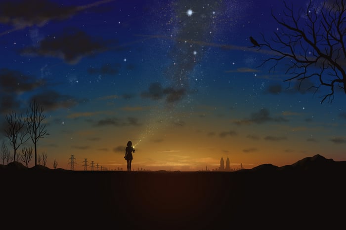 Girl holding light under starry sky
