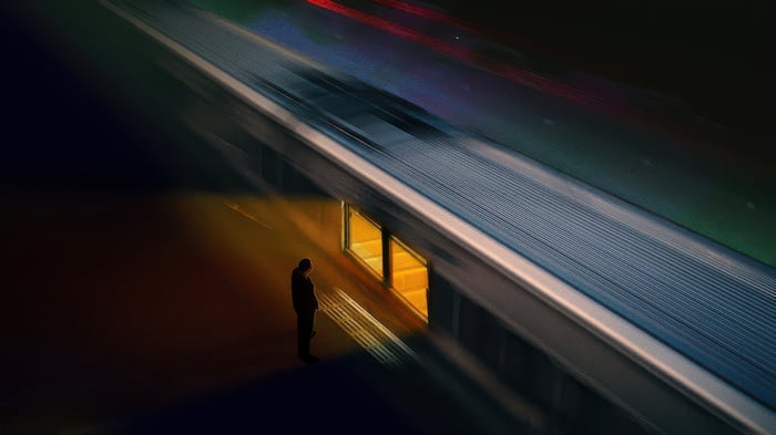 Man waits by train at night