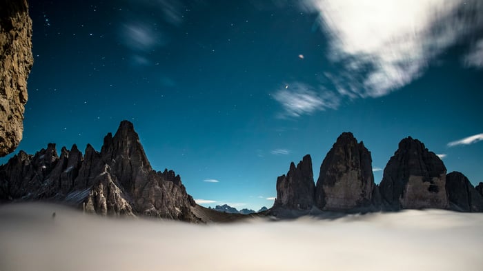 Dolomites Mountain Range at Night with Stars and Clouds