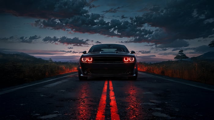 Dodge Challenger with glowing red headlights on a wet road