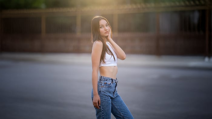 Girl in white top and jeans looking at viewer