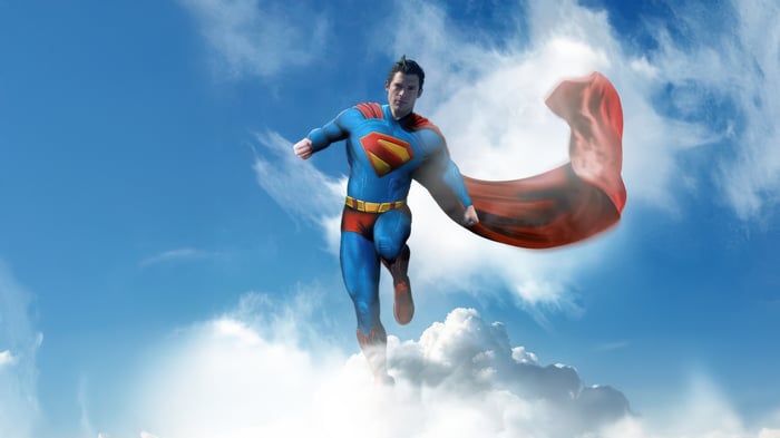 Superman flying through the sky with his cape
