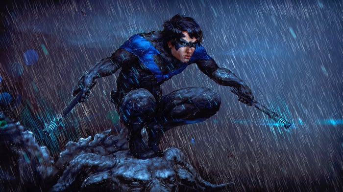 Nightwing crouches in the rain with escrima sticks