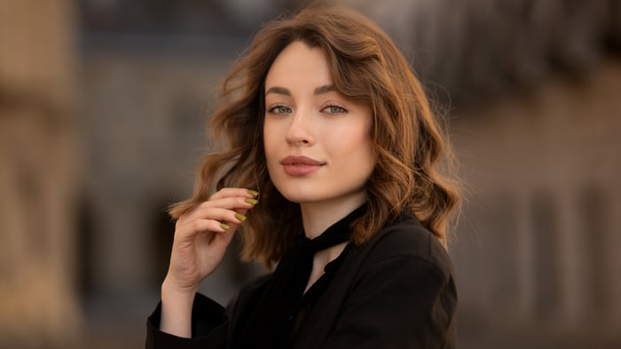 Woman with curly brown hair and black scarf