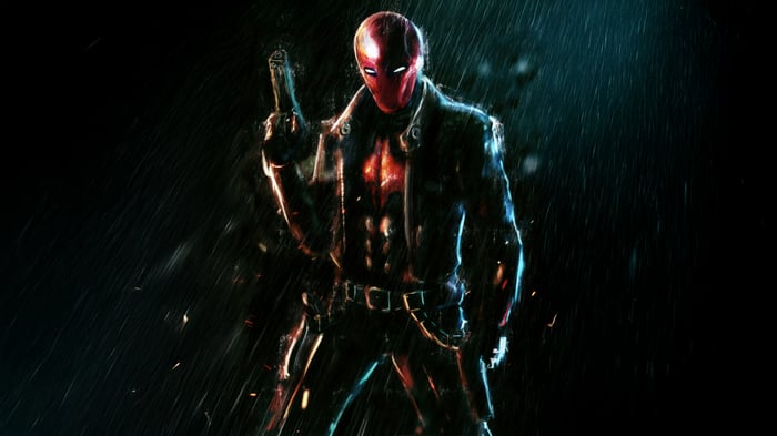 Red Hood holding a gun in the rain