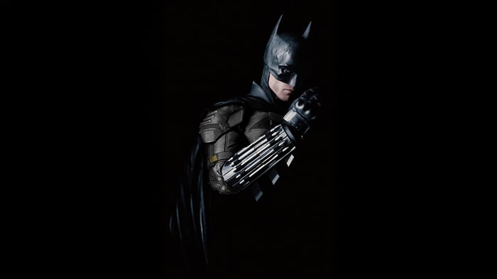 Batman in a dark suit with a cape