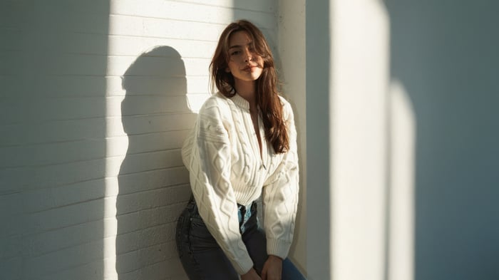 Celine Farach leaning against a wall in sunlight