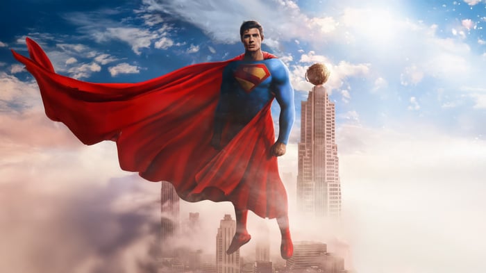Superman flying above clouds with city buildings