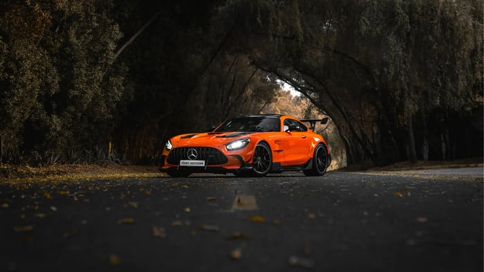Orange Mercedes-AMG GT R on a Tree-Lined Road
