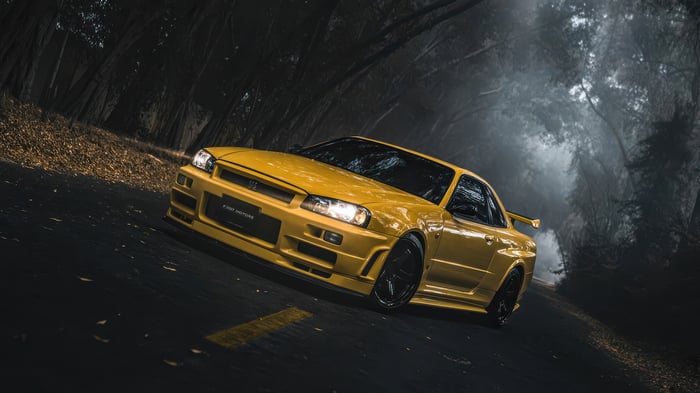 Yellow 1999 Nissan Skyline GTR on a foggy road