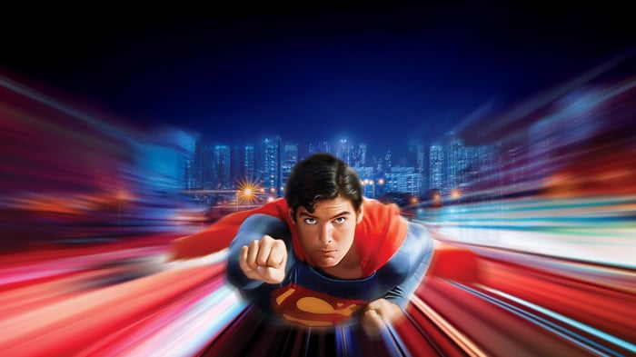 Christopher Reeve as Superman flying through a city at night