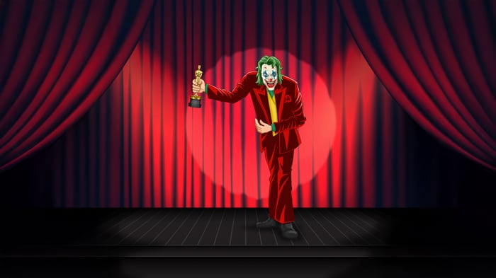 Joker holding an Oscar award on stage