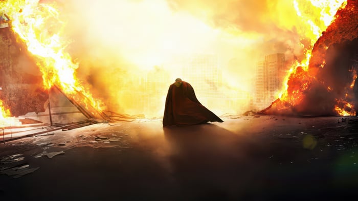 Superman stands alone in a burning city