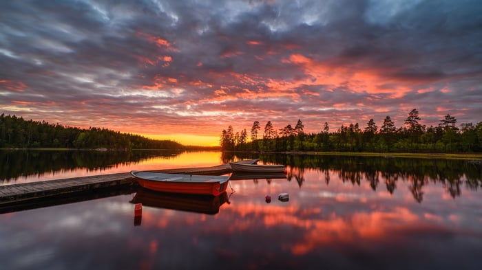 Sunset over a lake with boats and reflections