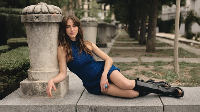 Andy Duato in a blue dress and black boots