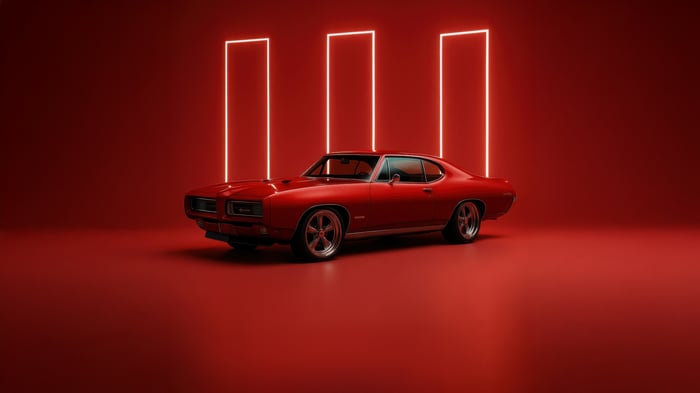 Red Pontiac GTO in a studio with neon lights