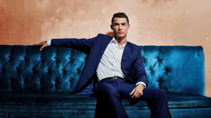 Cristiano Ronaldo in a blue suit on a blue couch