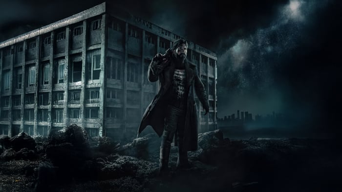 The Punisher stands in front of a ruined building