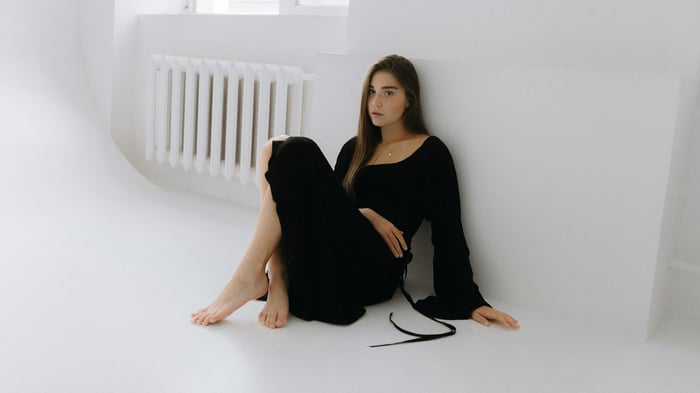 Girl in black dress sitting on the floor